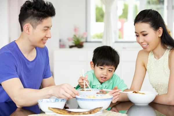 Família chinesa sentada em casa comendo uma refeição — Fotografia de Stock