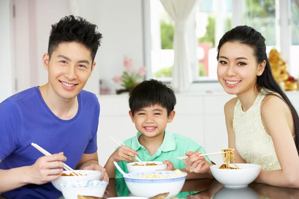 Família chinesa sentada em casa comendo uma refeição — Fotografia de Stock