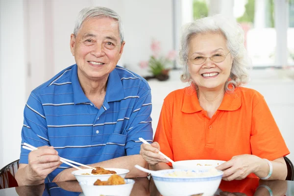 Senior pareja china sentada en casa comiendo comida —  Fotos de Stock