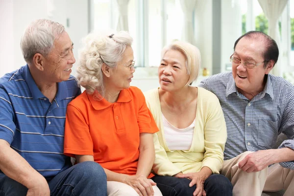 Grupo de amigos chineses seniores relaxando no sofá em casa — Fotografia de Stock