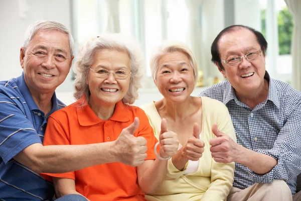 Gruppo di amici cinesi anziani che si rilassano sul divano a casa — Foto Stock