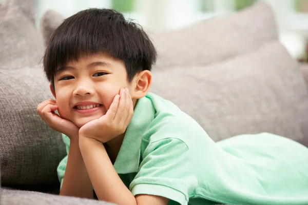 Jonge chinese jongen ontspannen op de sofa thuis — Stockfoto