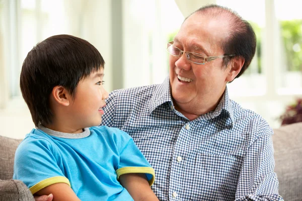 Chinese Grandfather And Grandson Relaxing On Sofa At Home — Stock Photo, Image