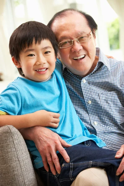 中国的祖父和孙子在家里的沙发上放松 — 图库照片