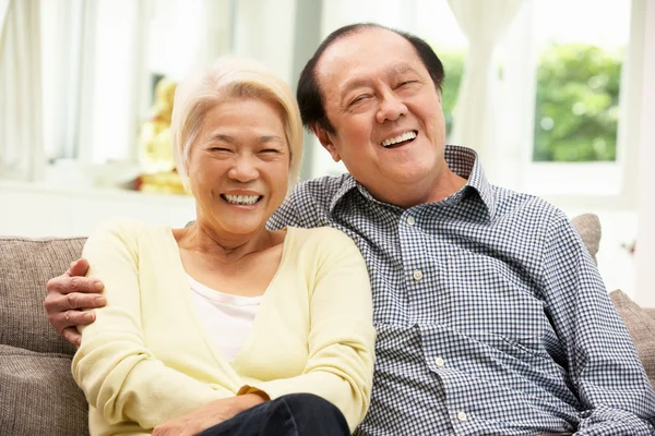 Senior chinesisches Paar entspannt sich auf Sofa zu Hause — Stockfoto