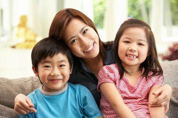 Chinesische Mutter und Kinder sitzen zu Hause zusammen auf dem Sofa — Stockfoto