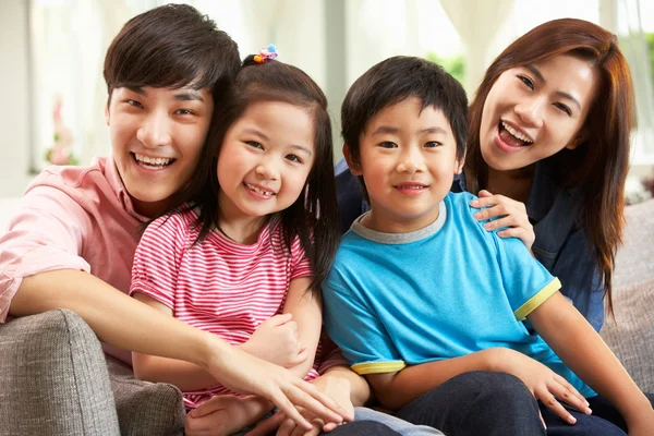 Família chinesa relaxando no sofá em casa — Fotografia de Stock