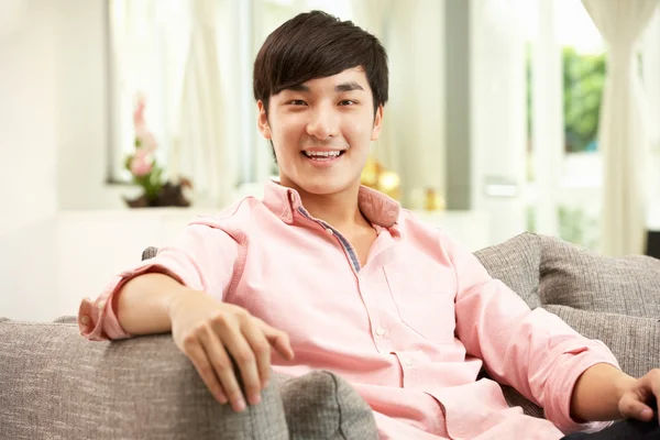 Young Chinese Man Relaxing On Sofa At Home — Stock Photo, Image