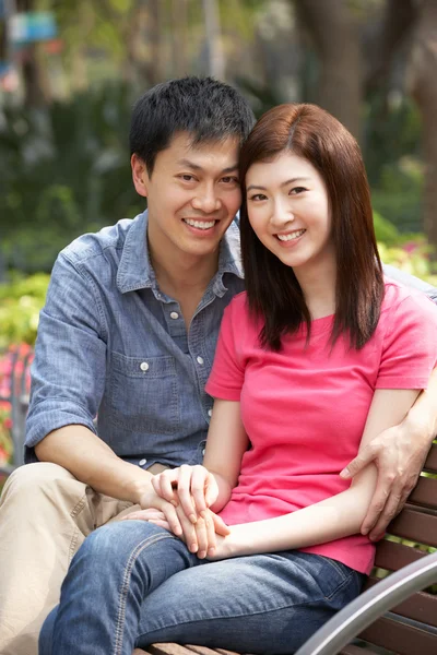 Joven pareja china relajándose en el banco del parque juntos — Foto de Stock