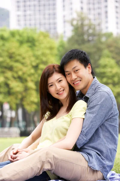 Unga kinesiska par avkopplande i parken tillsammans — Stockfoto