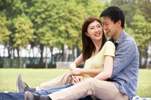 Jovem casal chinês relaxando no parque juntos — Fotografia de Stock