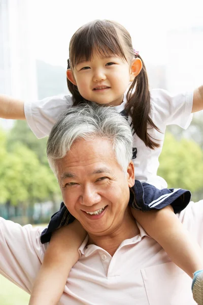 Chinees grootvader geven kleindochter rit op schouders in pa — Stockfoto