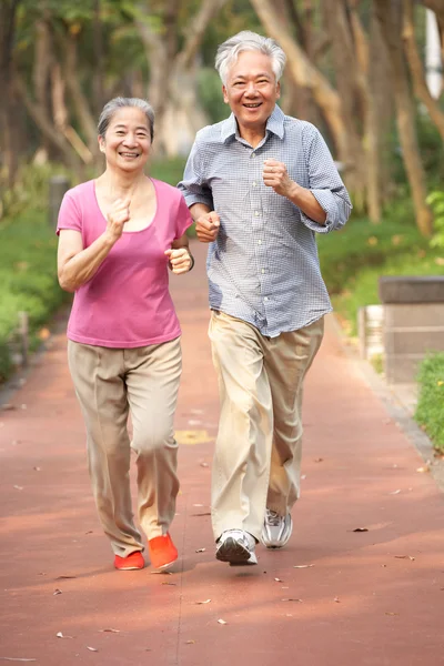 Vysocí čínští pár běhání v parku — Stock fotografie