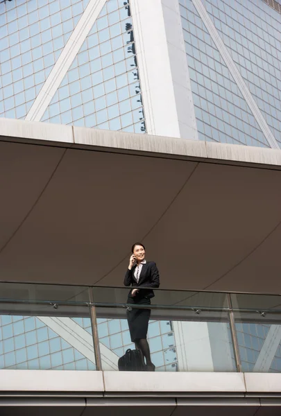 Chinese zakenvrouw buiten kantoor op mobiele telefoon — Stockfoto