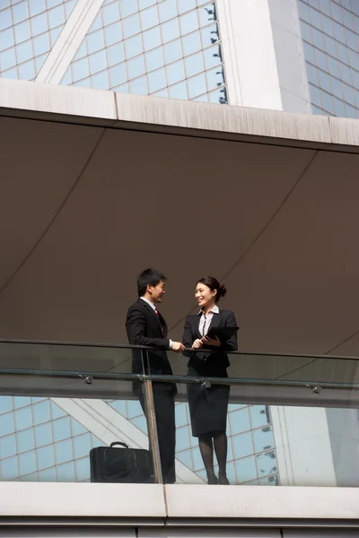 Dos colegas de negocios discutiendo fuera del edificio de oficinas — Foto de Stock