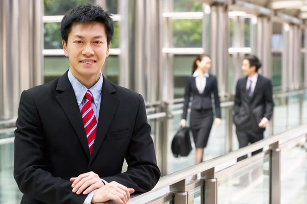 Portret chińskiego biznesmena poza biuro z kolegami i — Zdjęcie stockowe