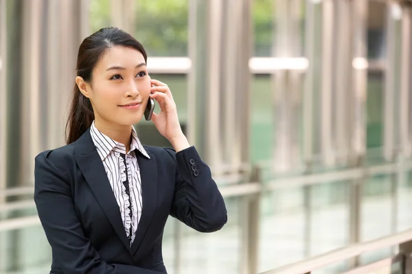 Kinesisk affärskvinna utanför kontoret på mobiltelefon — Stockfoto