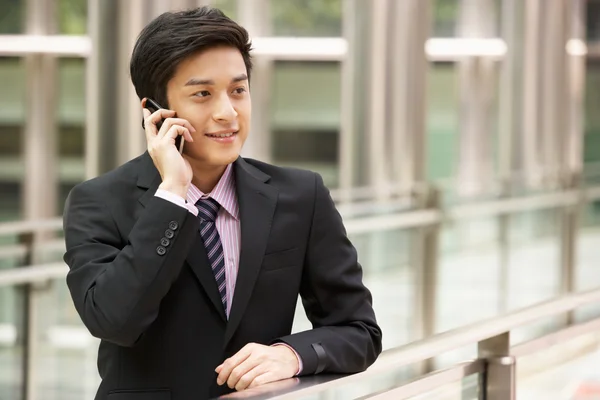 Čínský obchodník mimo kancelář na mobilním telefonu — Stock fotografie