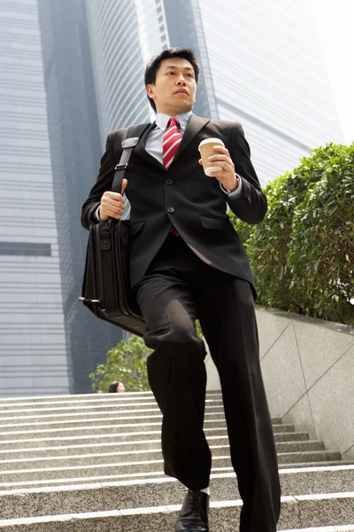 Imprenditore cinese che corre giù passi portando borsa e take away — Foto Stock