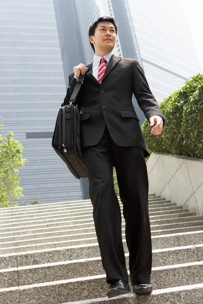 Chinesischer Geschäftsmann geht die Treppe hinunter und trägt Tasche außerhalb von offi — Stockfoto