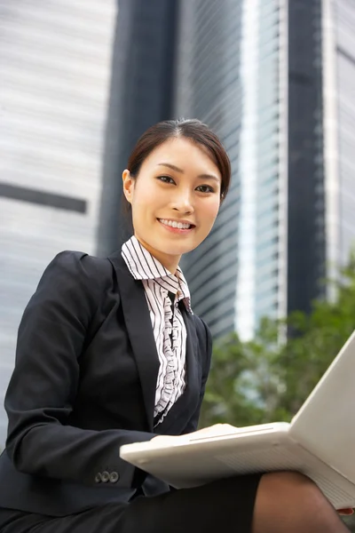 Chinese zakenvrouw bezig met laptop buiten kantoor — Stockfoto