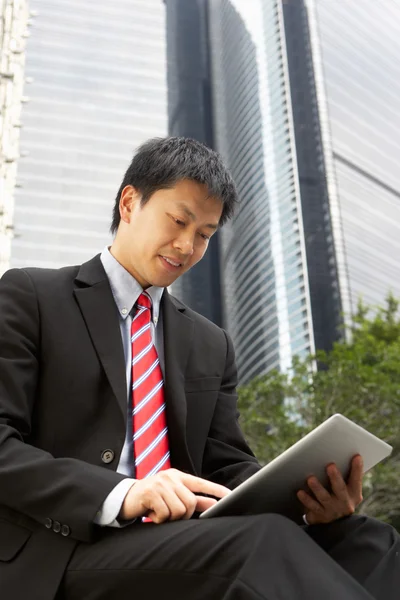 Chinesischer Geschäftsmann arbeitet außerhalb des Büros an Tablet-Computer — Stockfoto