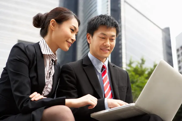 Chinesische Geschäftsfrau und Geschäftsfrau arbeitet draußen am Laptop — Stockfoto