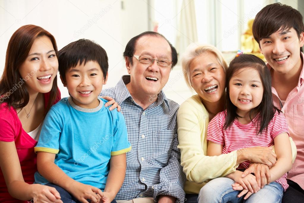 Portrait Of Multi-Generation Chinese Family Relaxing At Home Tog ...