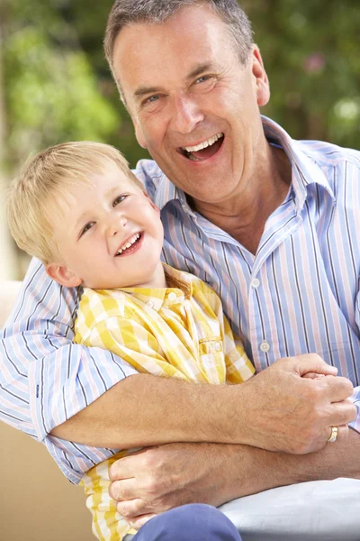 Grootvader en kleinzoon ontspannen op de sofa samen — Stockfoto