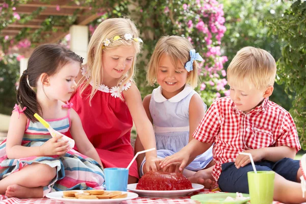 Groep kinderen eten gelei op buiten tea party — Stockfoto