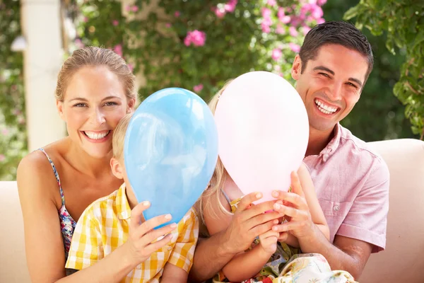 Familie zittend op de Bank samen met ballonnen — Stockfoto