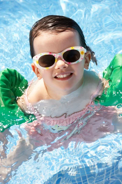 Retrato de menina com braçadeiras na piscina — Fotografia de Stock