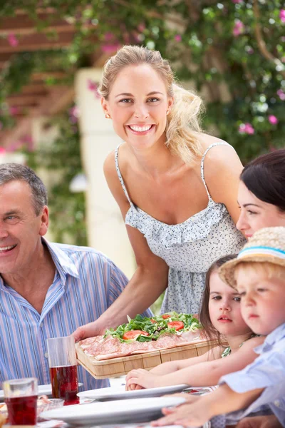 Frau serviert bei Mehrgenerationen-Familienessen — Stockfoto