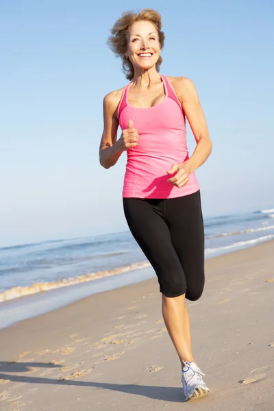 Mujer mayor haciendo ejercicio en la playa — Foto de Stock