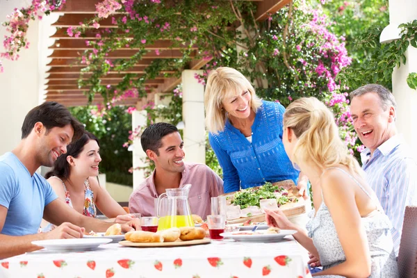 Groep van jonge en senior paren genieten van familie maaltijd — Stockfoto