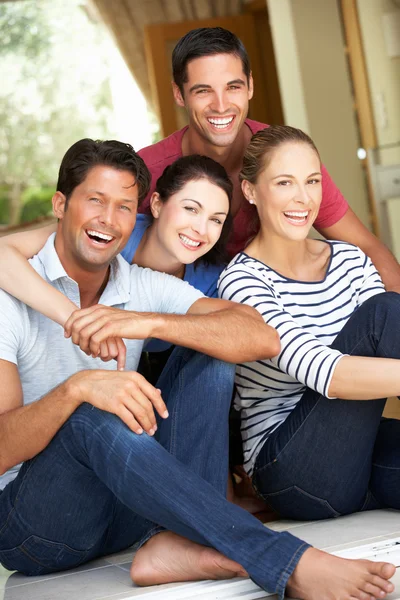 Grupo de amigos sentados fuera de la casa — Foto de Stock