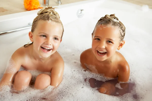 Две девушки, играющие в ванной вместе — стоковое фото