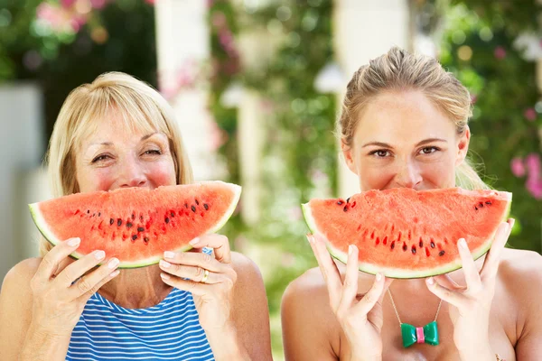Matka a dospělý dcera užívat plátky vodního melounu — Stock fotografie