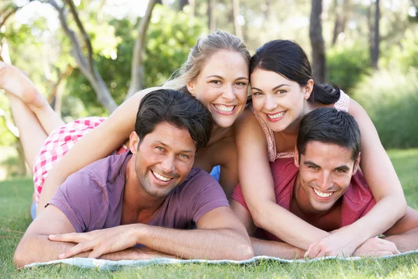 Grupp vänner tillsammans att koppla av i park — Stockfoto