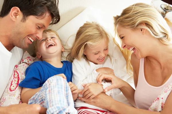 Familia relajándose juntos en la cama — Foto de Stock