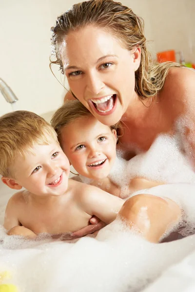 Mère avec des enfants se détendre dans le bain rempli de bulles — Photo