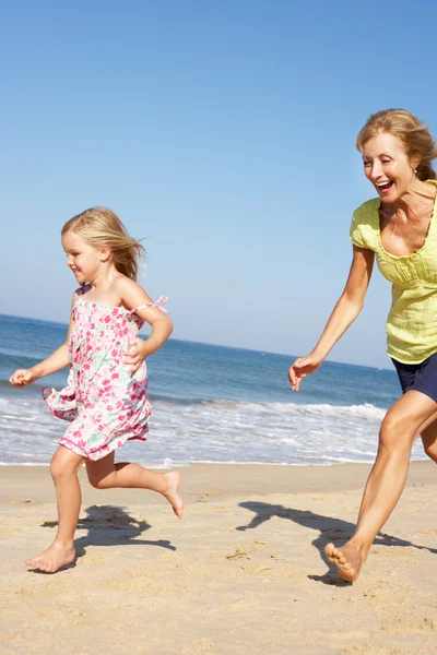 Бабушка и внучка бегут вдоль пляжа — стоковое фото