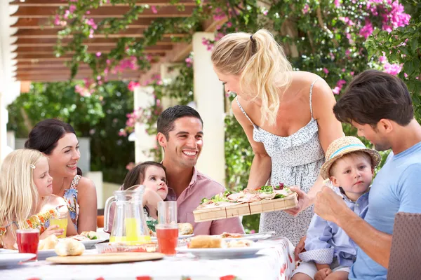 Frau serviert zwei Familien Mahlzeit — Stockfoto