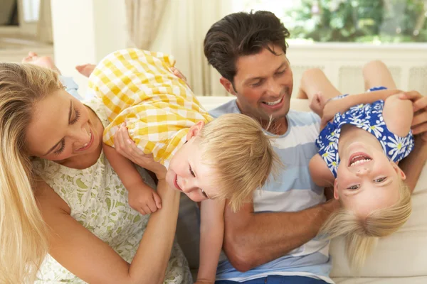 Familj spelar på soffan hemma — Stockfoto