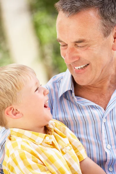 Grootvader en kleinzoon ontspannen op de sofa samen — Stockfoto