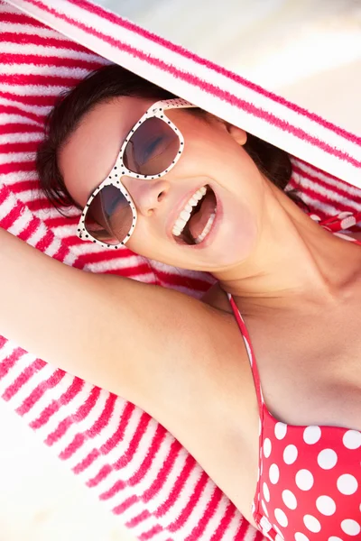 Frau schützt sich im Strandurlaub vor Sonne — Stockfoto