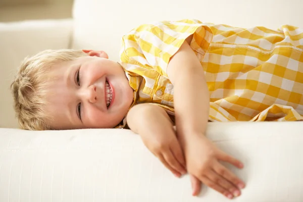 Kleiner Junge entspannt auf dem Sofa zu Hause — Stockfoto