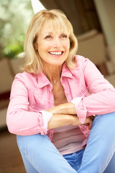 Seniorin sitzt vor Haus — Stockfoto