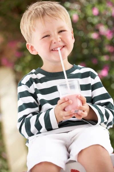 Junge in Gummistiefeln trinkt Milchshake — Stockfoto