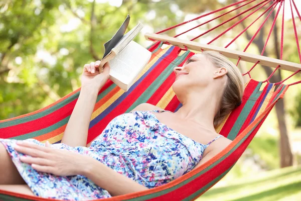 Mujer relajante en hamaca con libro — Foto de Stock